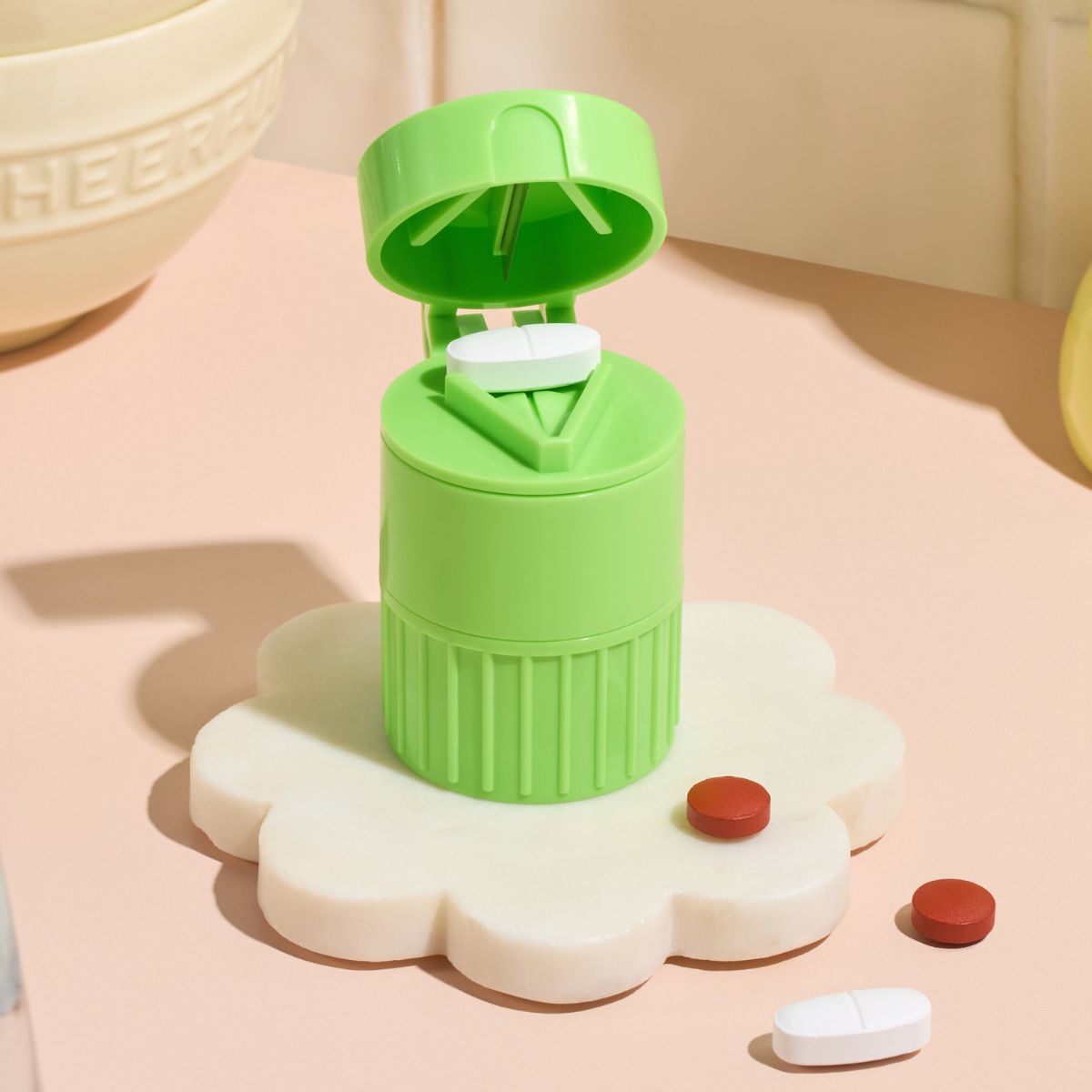 Green Pill Compartment and Pill Cutter by Cost Price Supplements on a kitchen bench
