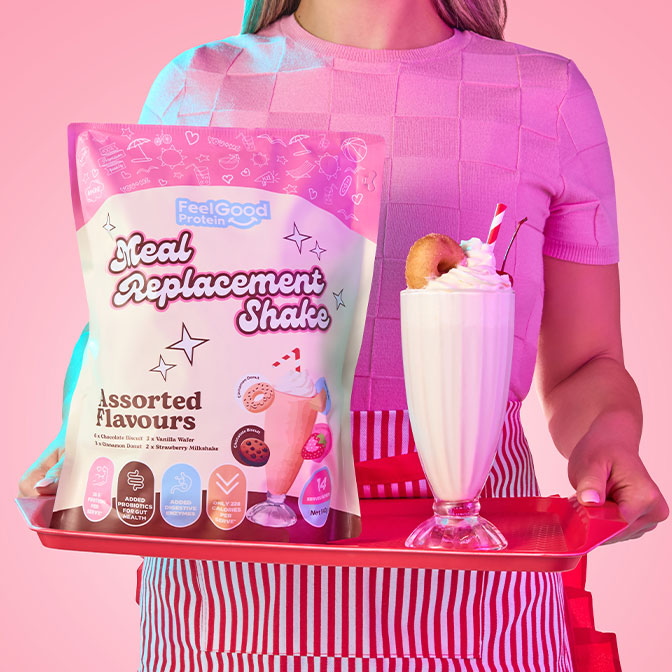 Meal Replacement Shake Assorted Pack by Feel Good Protein on a red tray next to a cinnamon donut milkshake held by a waiter