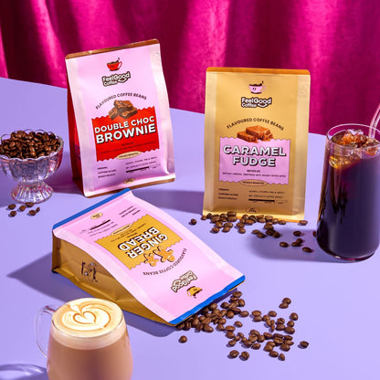 Feel Good Coffee packages with coffee beans and drinks on a purple surface