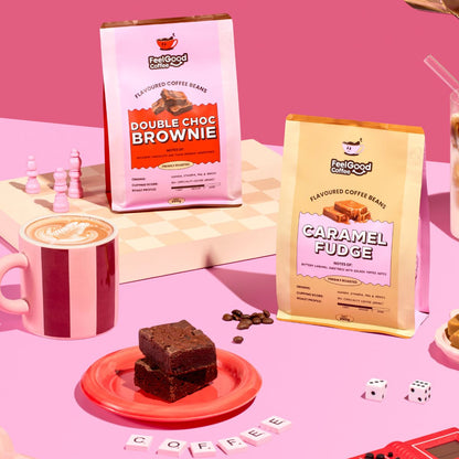 Brownie & Caramel Fudge coffee beans by Feel Good Coffee on a pink table next to brownie slices and a hot coffee