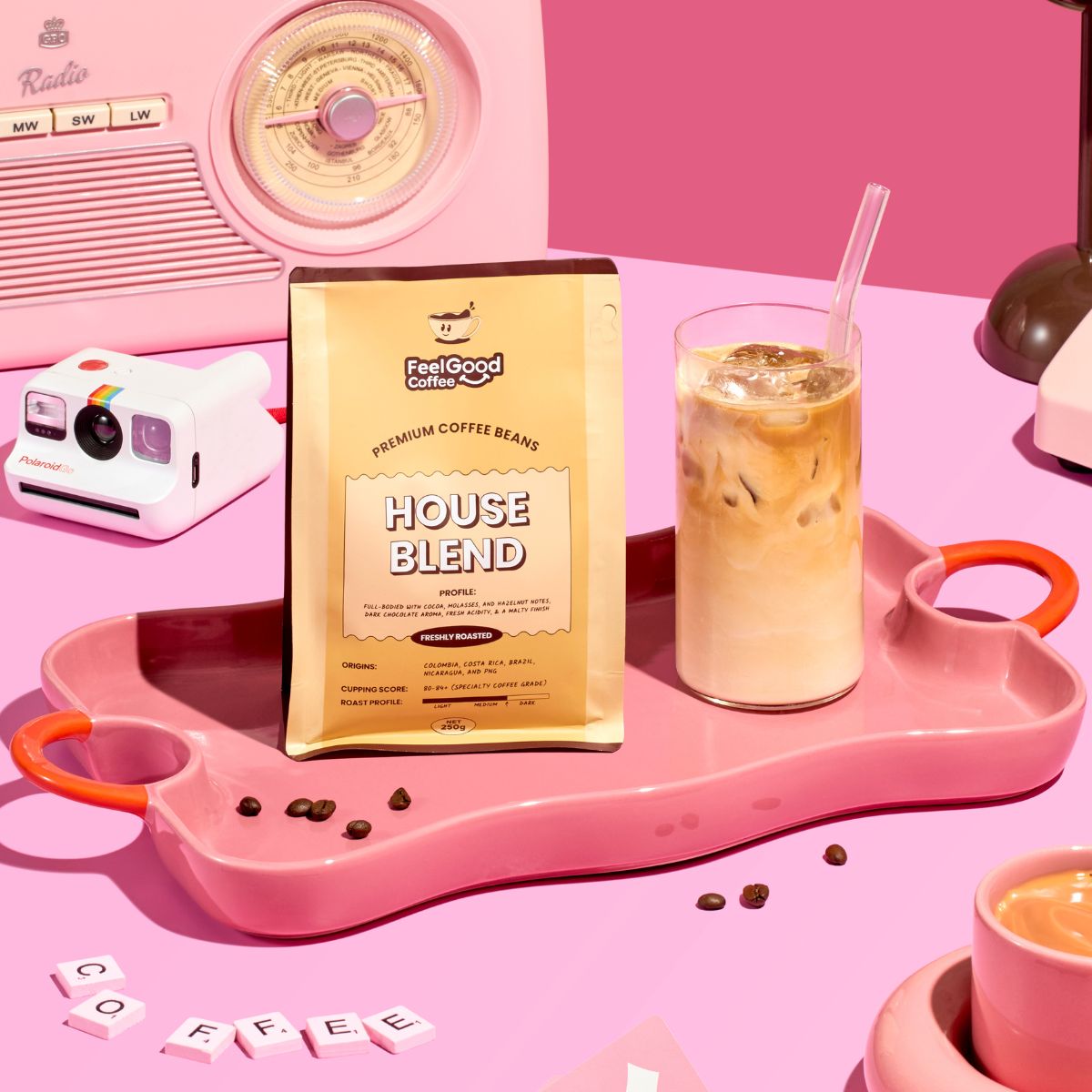 House Blend by Feel Good Coffee next to an iced latte on a pink table