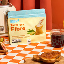 Tasteless Fibre by Feel Good Protein on checkered tablecloth next to coffee