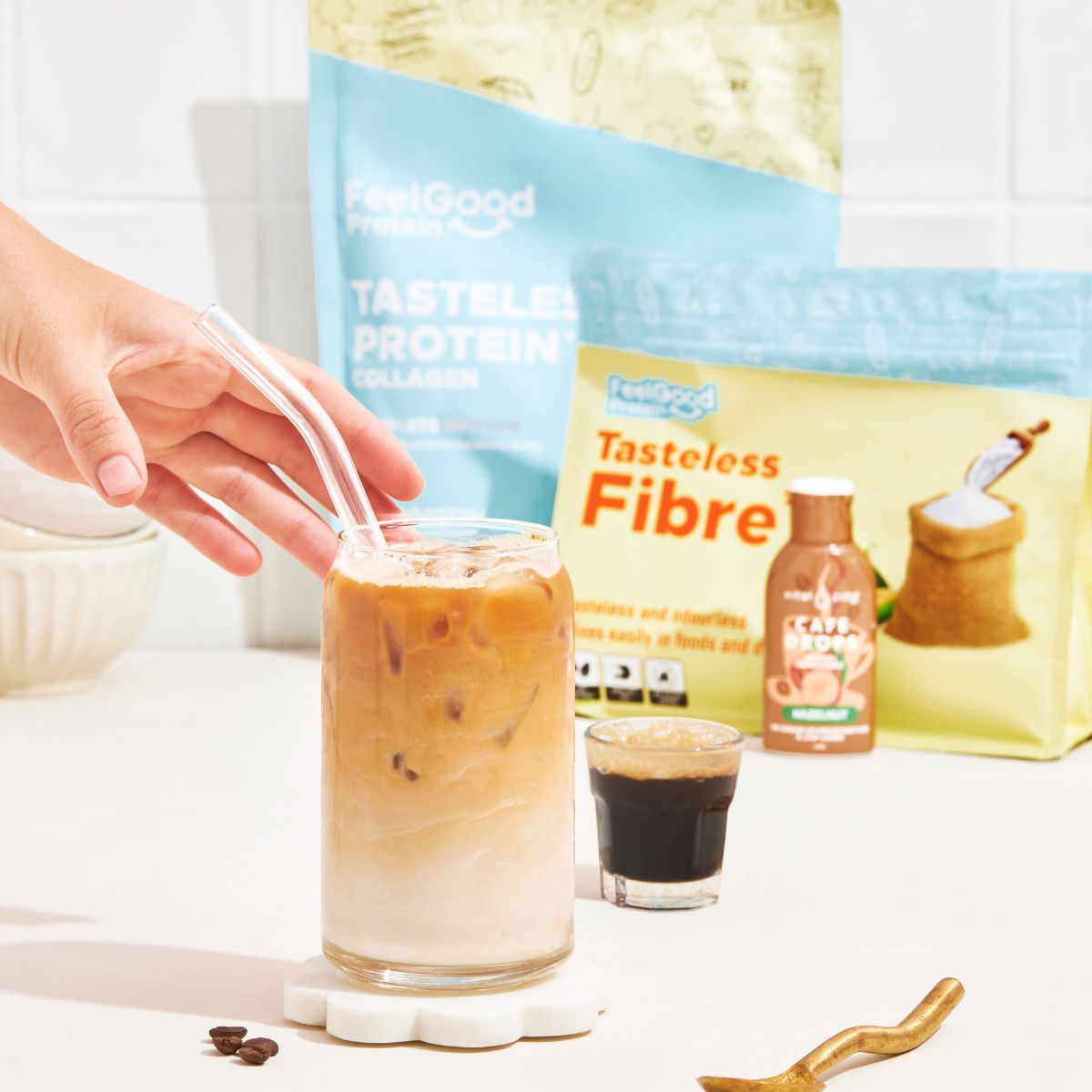 Tasteless Fibre and Tasteless Protein Bundle Pack by Feel Good Protein behind iced coffee