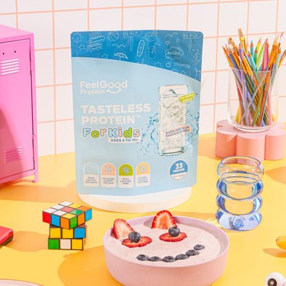 Tasteless Protein for Kids by Feel Good Protein on a school desk next to bowl of fruit yoghurt