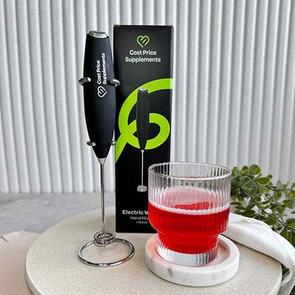 Cost Price Supplements Electric Whisk on its stand next to a red drink in clear glass